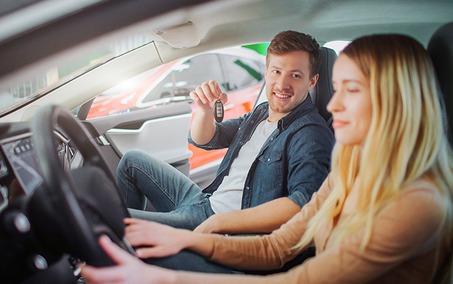 Young Family Buying First Electric Car In The Showroom. Attracti